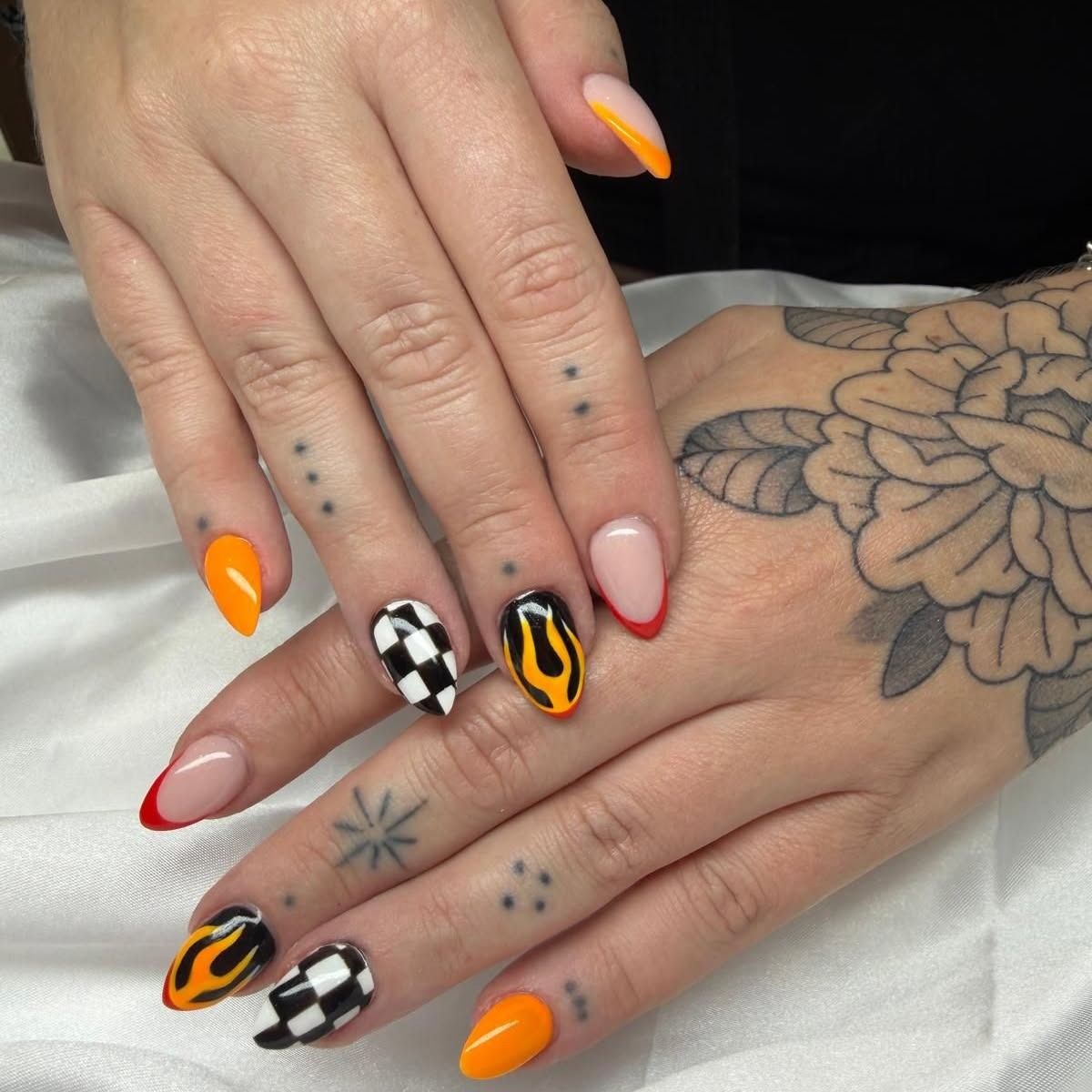 Oranje nagels met vlammen en een geblokte vlag
