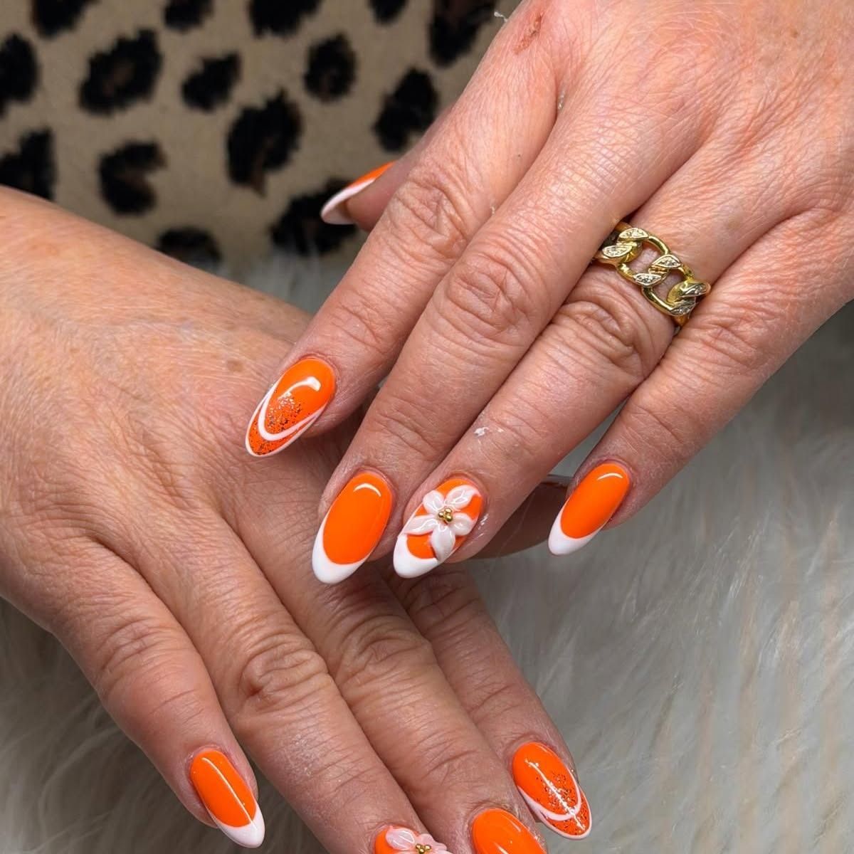Oranje nagels met een bloem